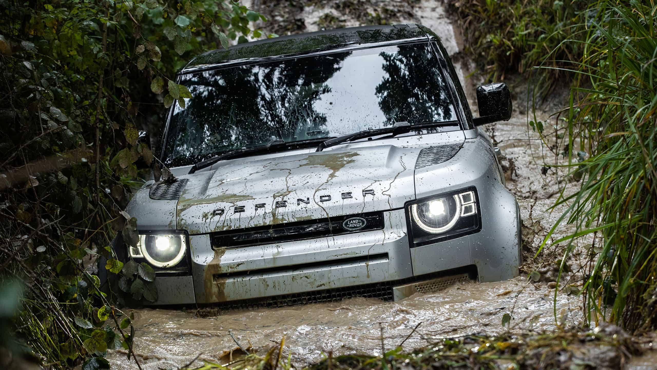 Defender wading through muddy water